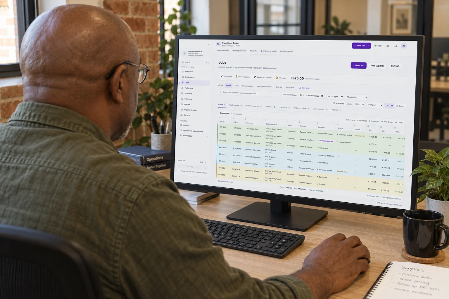 AI illustration viewed over an older broker’s shoulder as he uses the PaperRoute Broker job register in a brick office